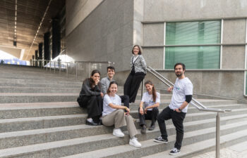 IVY volunteers in Brussels, sitting on a stair and smiling
